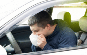 車内で嘔吐している男性イメージ写真