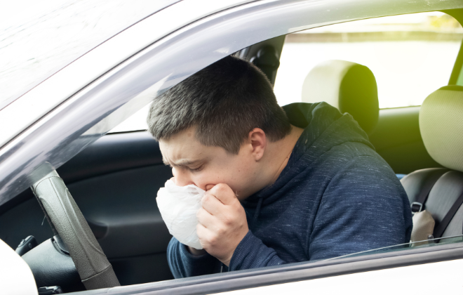 車内で嘔吐している男性イメージ写真