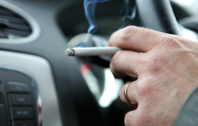 車内でタバコを吸っているイメージ写真