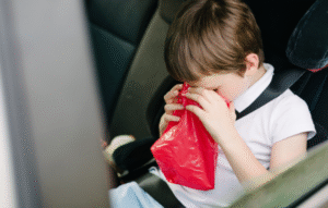 子供が車内で嘔吐しているイメージ写真