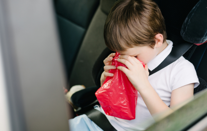 子供が車内で嘔吐しているイメージ写真