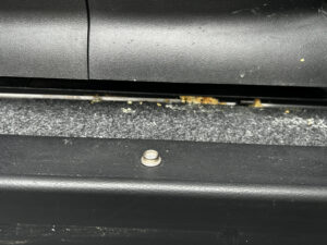 車のシートレールの隙間に入り込む吐瀉物イメージ写真