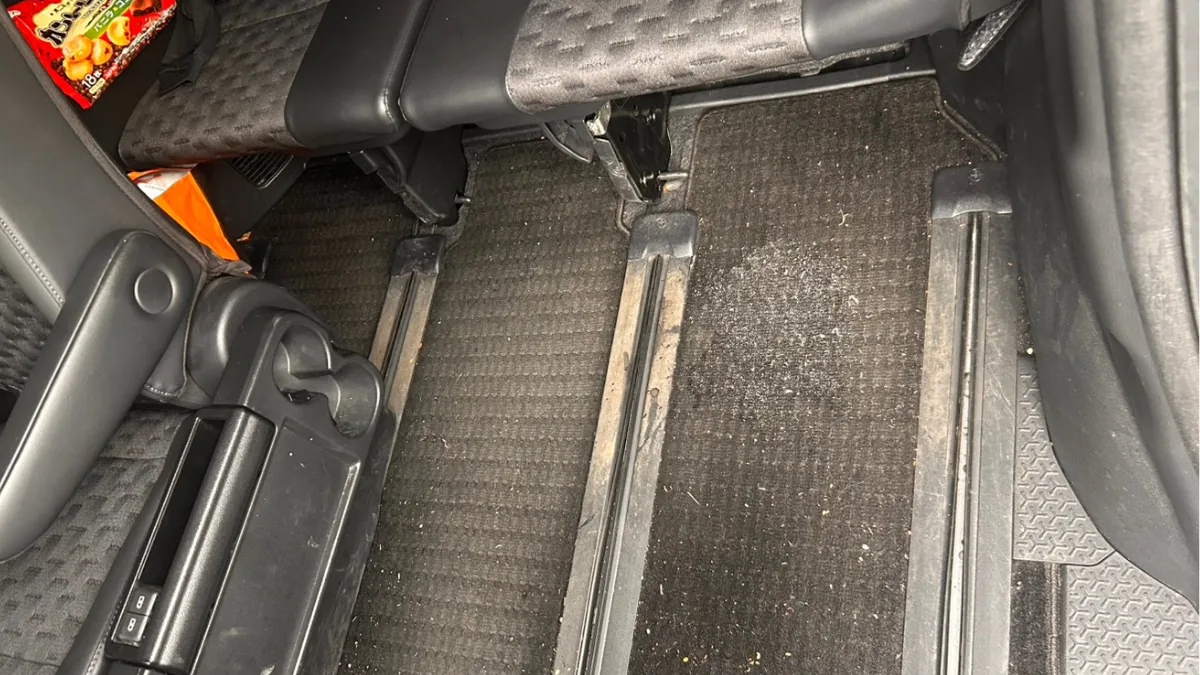 車内フロアとシート下に汚れが残っている清掃前イメージ