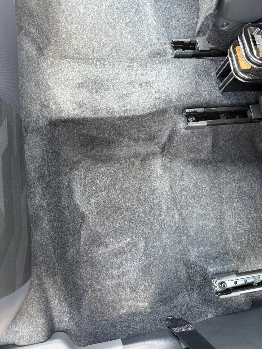 フロアマットを外した状態の車内の床。シートを前後に動かすためのレールが見えている
