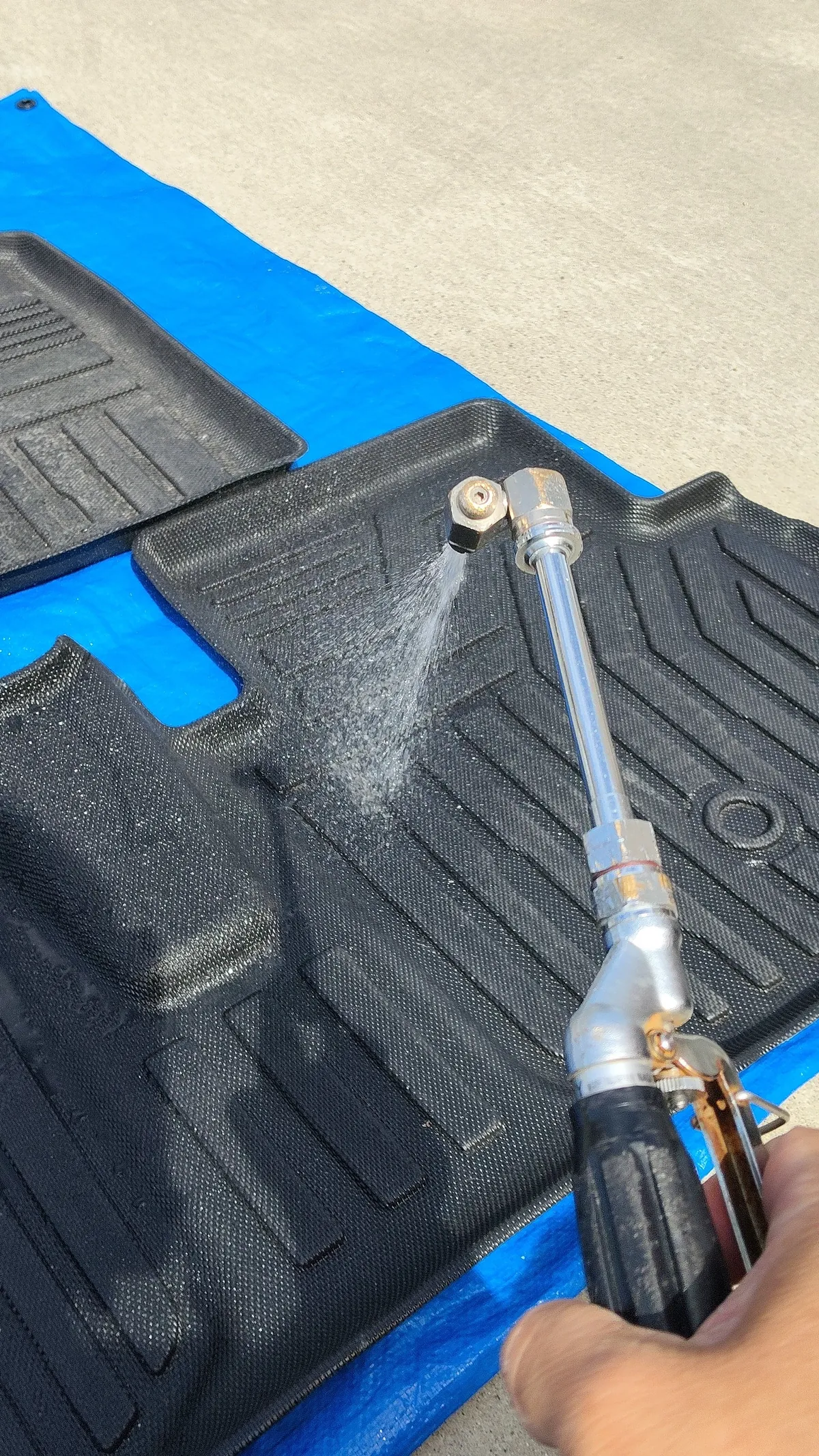 フロアマットに水をかけて流しているところ