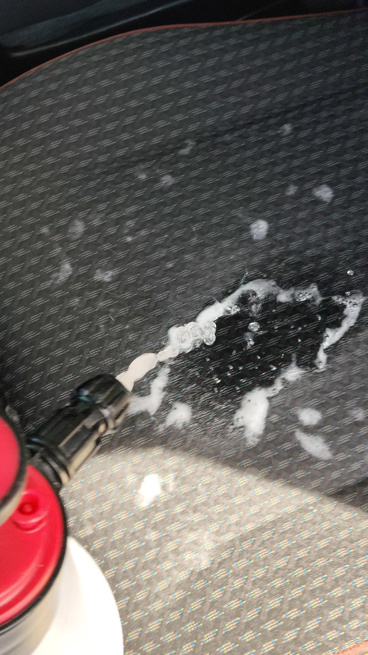 噴霧器を使って座面に液体をかけているところ
