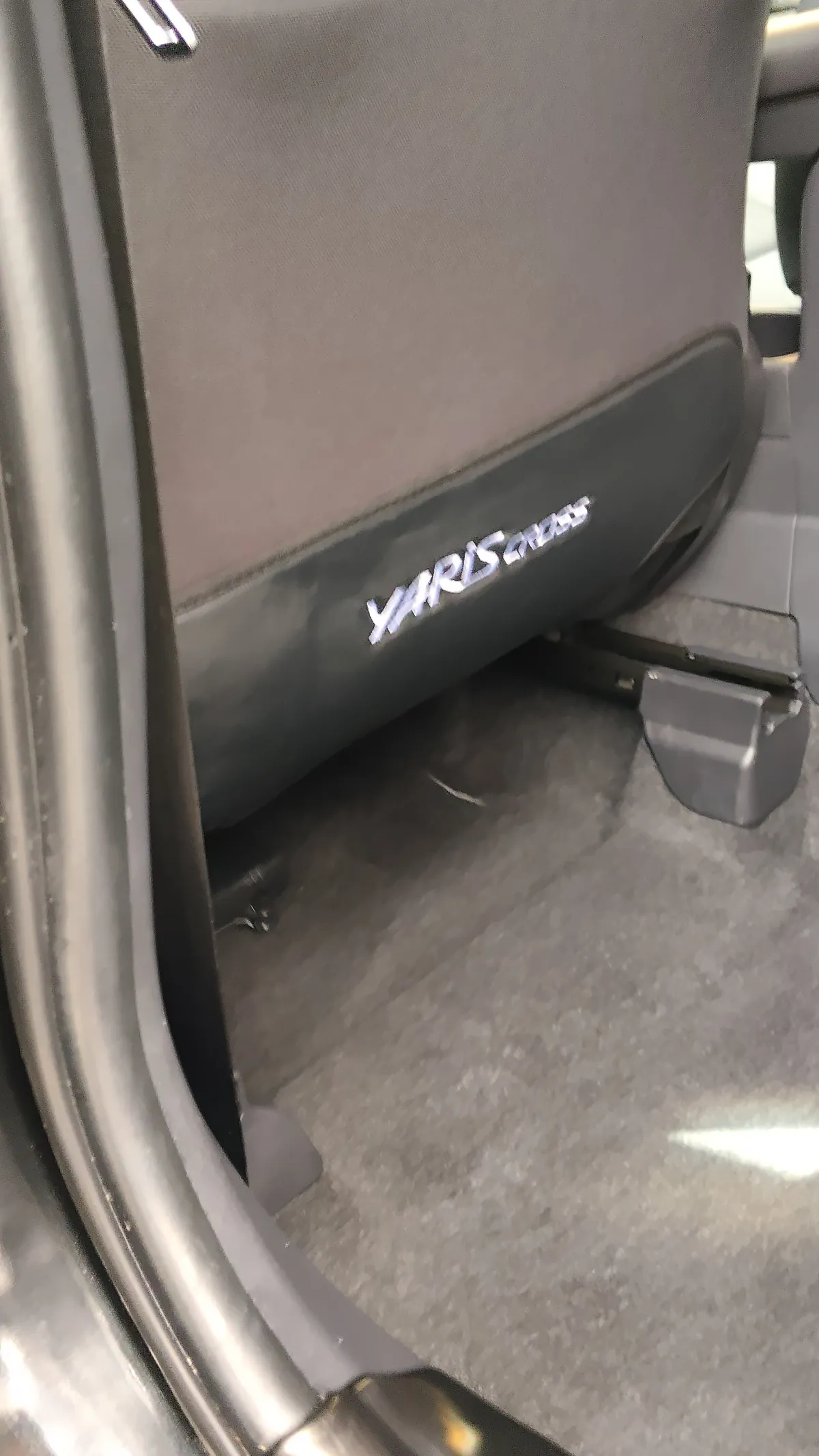 トヨタ ヤリスクロスの施工後。後部座席の足元を写した写真で、YARIS CROSSのロゴが入った部分とカーペットが見えている
