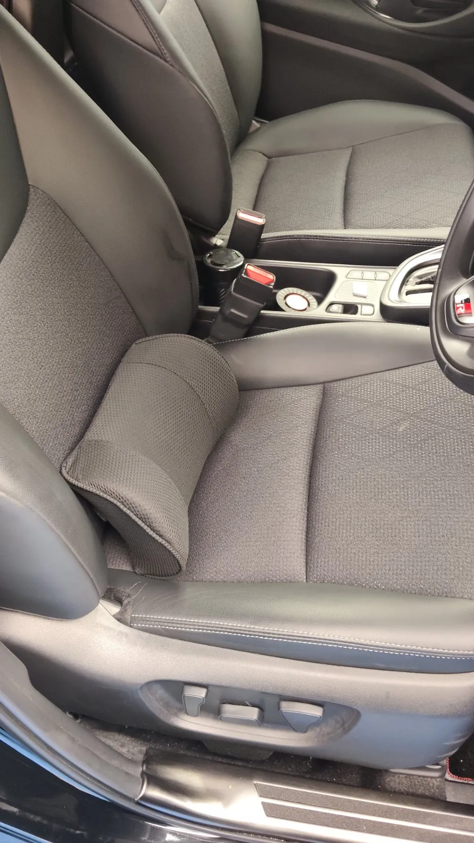 トヨタ ヤリスクロスの施工前。前席の運転席と助手席を写した写真で、黒い生地の座面とレザー調のふち、シートの調整スイッチ、センターコンソールが見えている