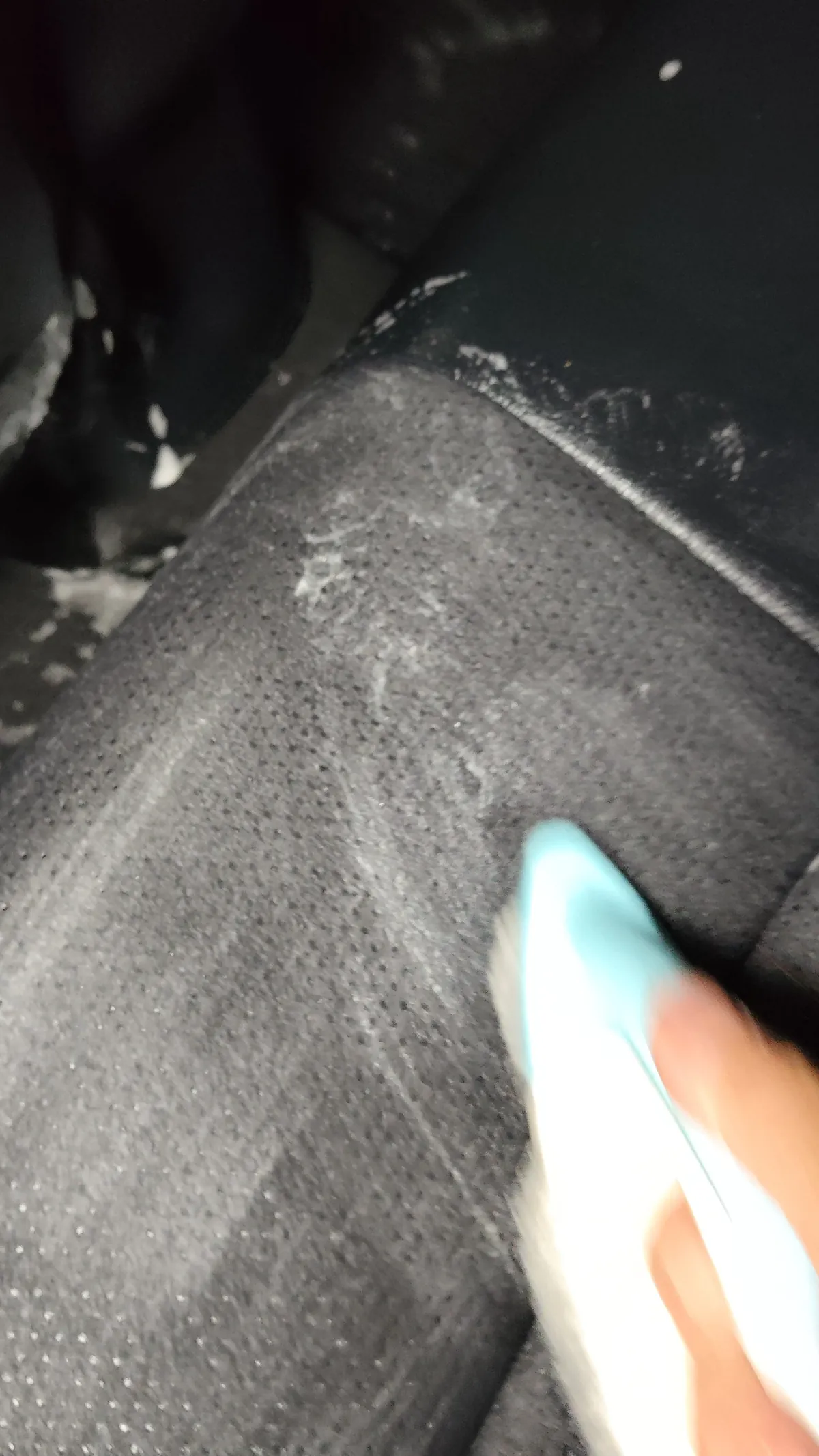 トヨタ ヤリスクロスの施工中。水色のブラシで座面の生地をこすっており、まわりに白い泡が残っている