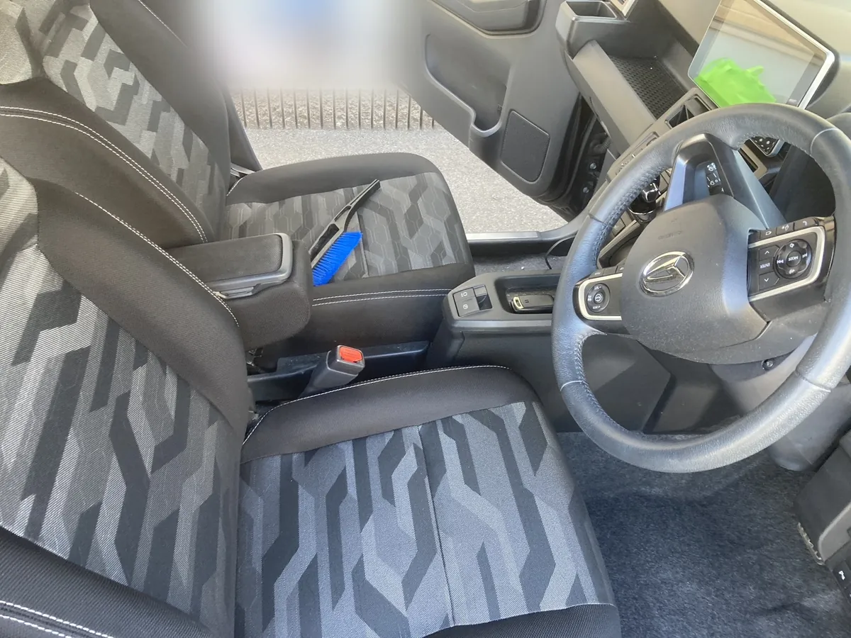 ダイハツ タフトの前席2脚と運転席まわり。助手席にブラシが置かれている