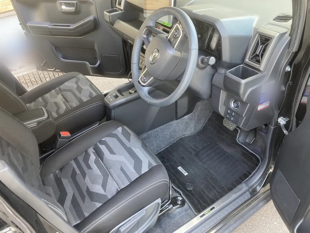 清掃を終えたダイハツ タフトの運転席まわり。ステアリングとシフト、TAFTのロゴが入ったフロアマット
