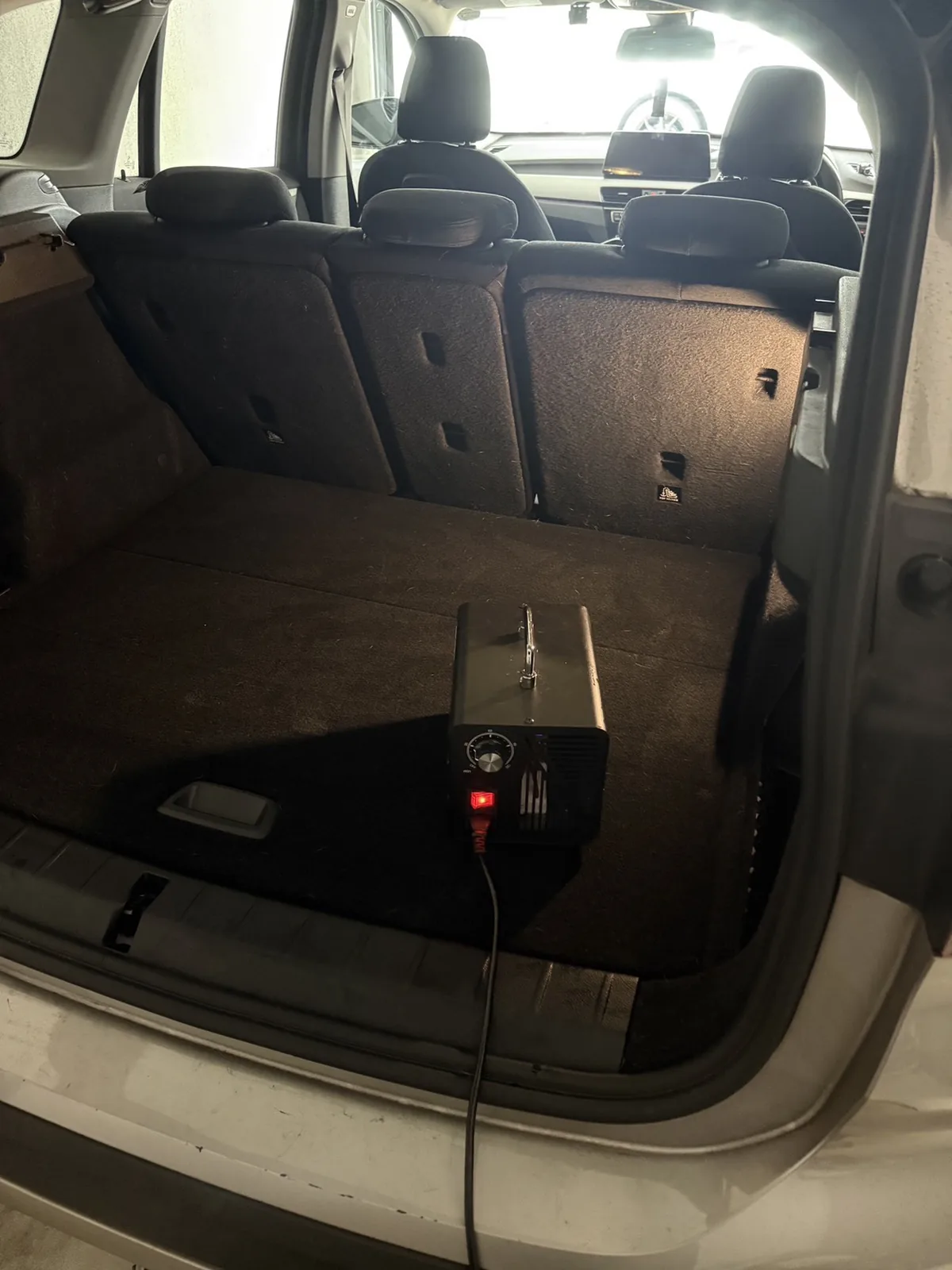 テールゲートを開けたBMW X1の荷室でオゾン発生器を稼働させているところ