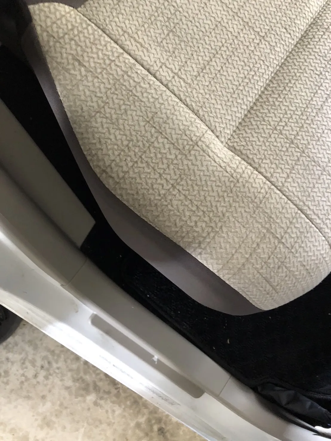 作業前の運転席の座面の縁と、乗り降りする部分。乗り降りで足が触れる部分にうっすら汚れ、マットの縁に白っぽい粒がある