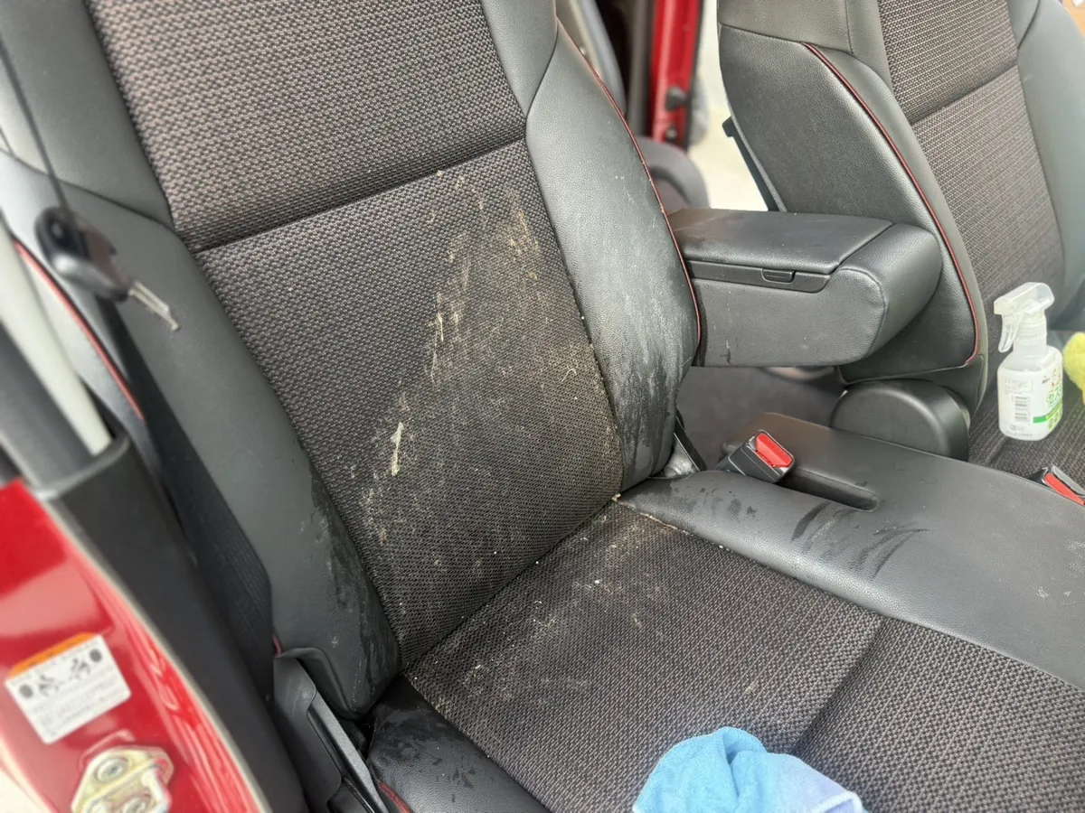 施工前のスズキ スペーシアカスタムの運転席まわり。座面と背もたれに嘔吐による汚れが広がり、アームレストにも汚れが及んでいる(埼玉県上尾市)