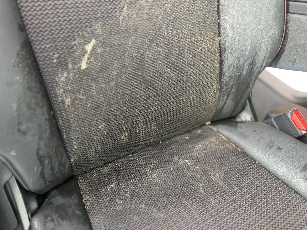 施工前のスズキ スペーシアカスタムの運転席。座面から背もたれにかけて嘔吐による黄土色の汚れが広範囲に付着している(埼玉県上尾市)