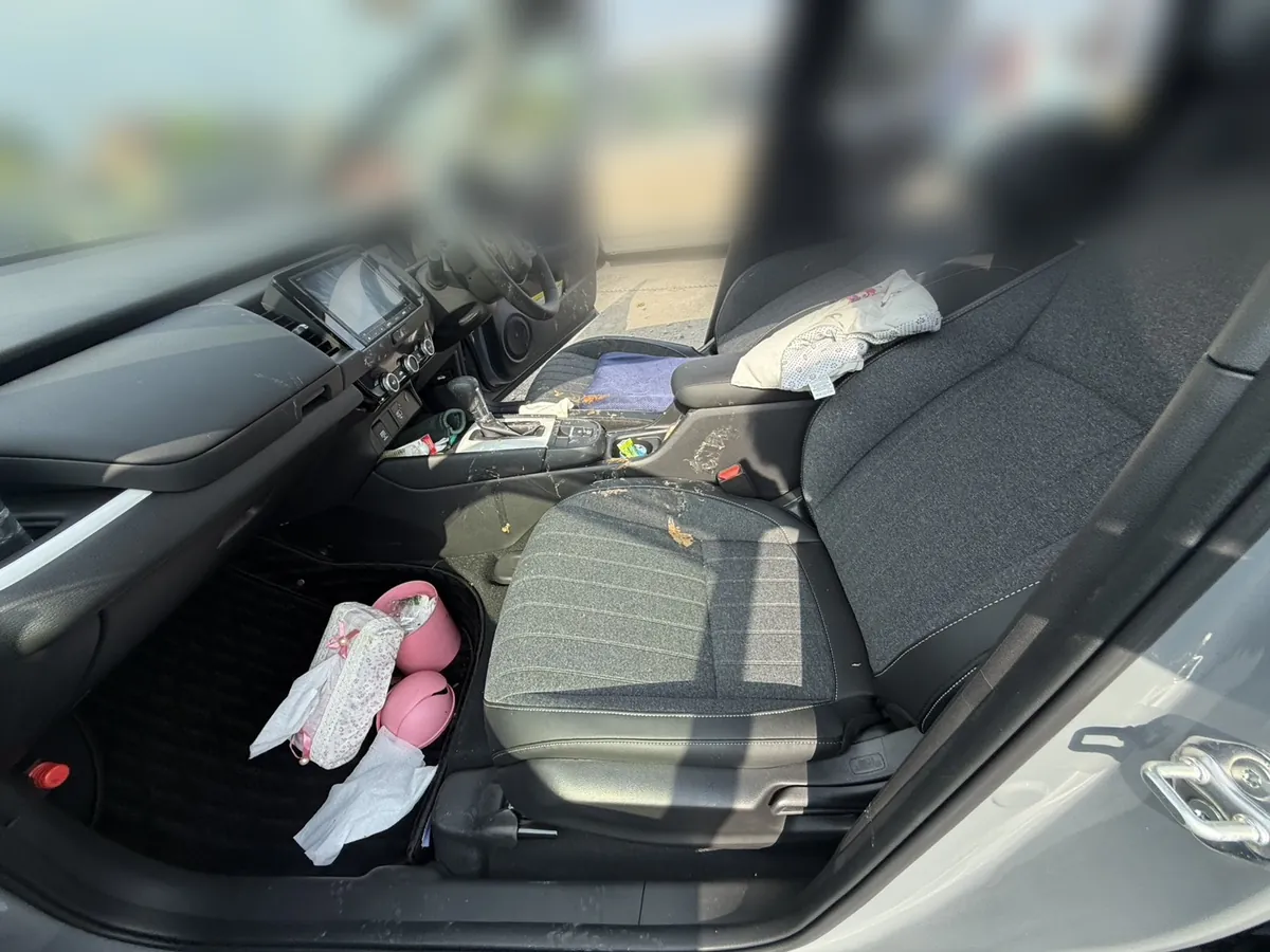 施工前のホンダ フィットの運転席まわり。座面・コンソール・床に嘔吐による汚れが広範囲に残っている様子