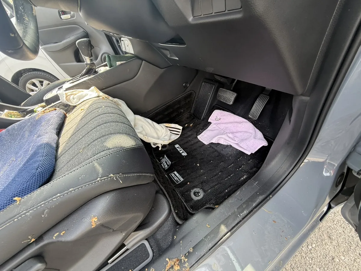 施工前のホンダ フィットの運転席足元。フロアマットとドア開口部まで汚れが及んでいる様子