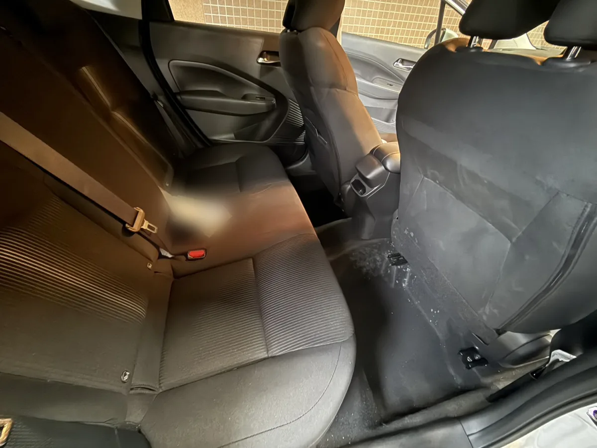 作業前の日産ノートの後部座席。ドアが開いた状態で、足元付近に白いものが散っている