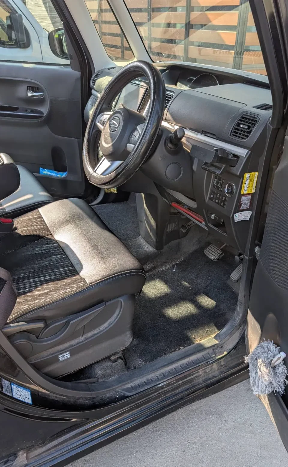 施工前の運転席側。ステアリングとシート、マットを外した足元のフロアカーペットが見える