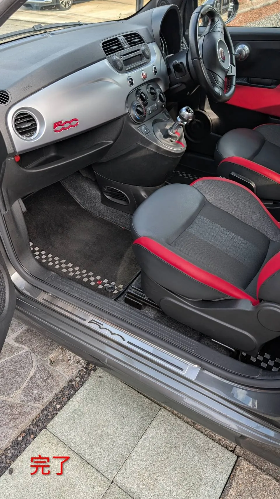 完了後のFIAT 500Sの車内全体。ダッシュボードに500のロゴ、助手席と運転席の座面、チェッカー柄のフロアマットが見える