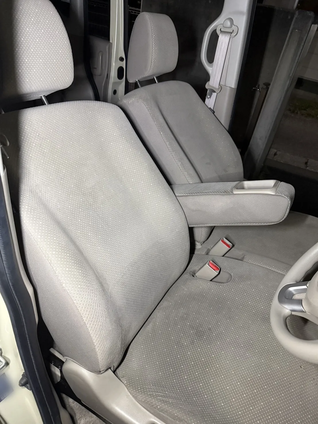 清掃後の運転席と助手席。運転席は背もたれを前に倒した状態で、ステアリングとアームレストが写る