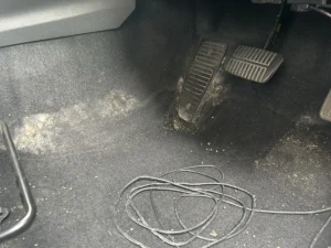 運転席の足元。ペダルまわりのカーペットに白い綿状のものが広く付着している（千葉県千葉市稲毛区・スバル インプレッサ）