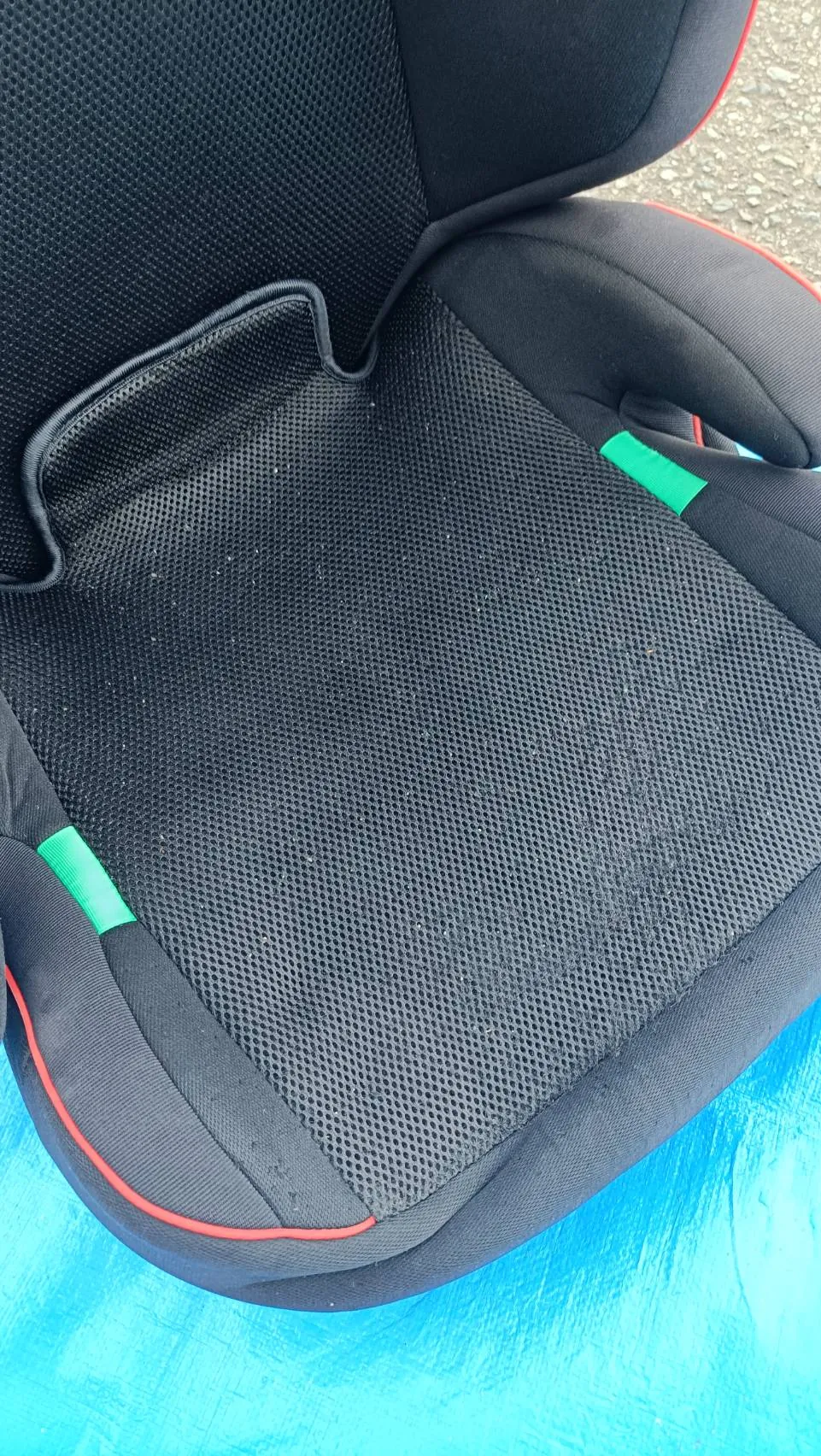 作業のあとのチャイルドシート。青いシートの上に置かれた黒いメッシュ地の座面で、広く付いていた汚れは見当たらない