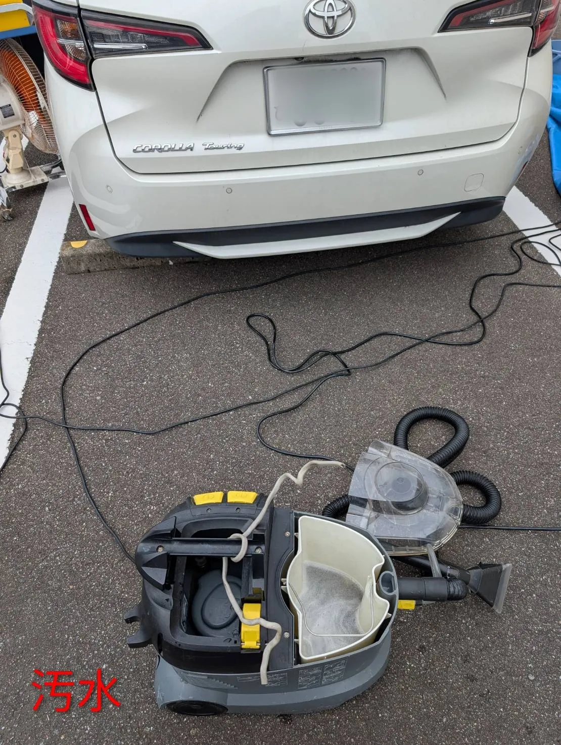 回収タンクを開けたところ。灰色に濁った水がたまり、表面に細かい泡が立っている