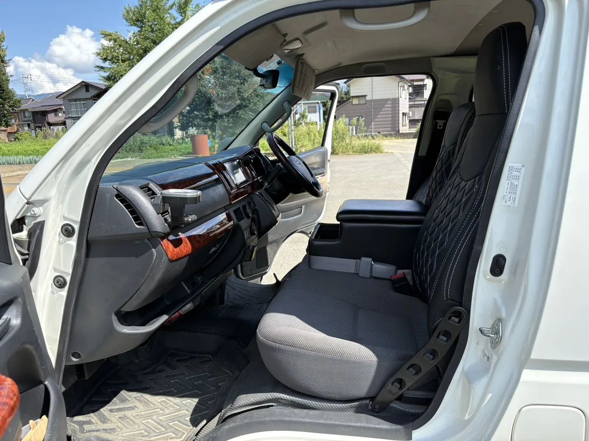 同じ運転席まわりを、作業のあとに助手席側から撮ったもの。木目調のダッシュボードとハンドル