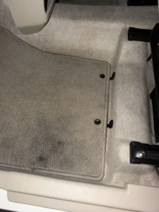 作業のあとの助手席の足元。1枚目と同じグレーのフロアマットで、同じ位置に留め具が2つある。ドア側の縁の近くに出ていた黒い跡が見当たらない