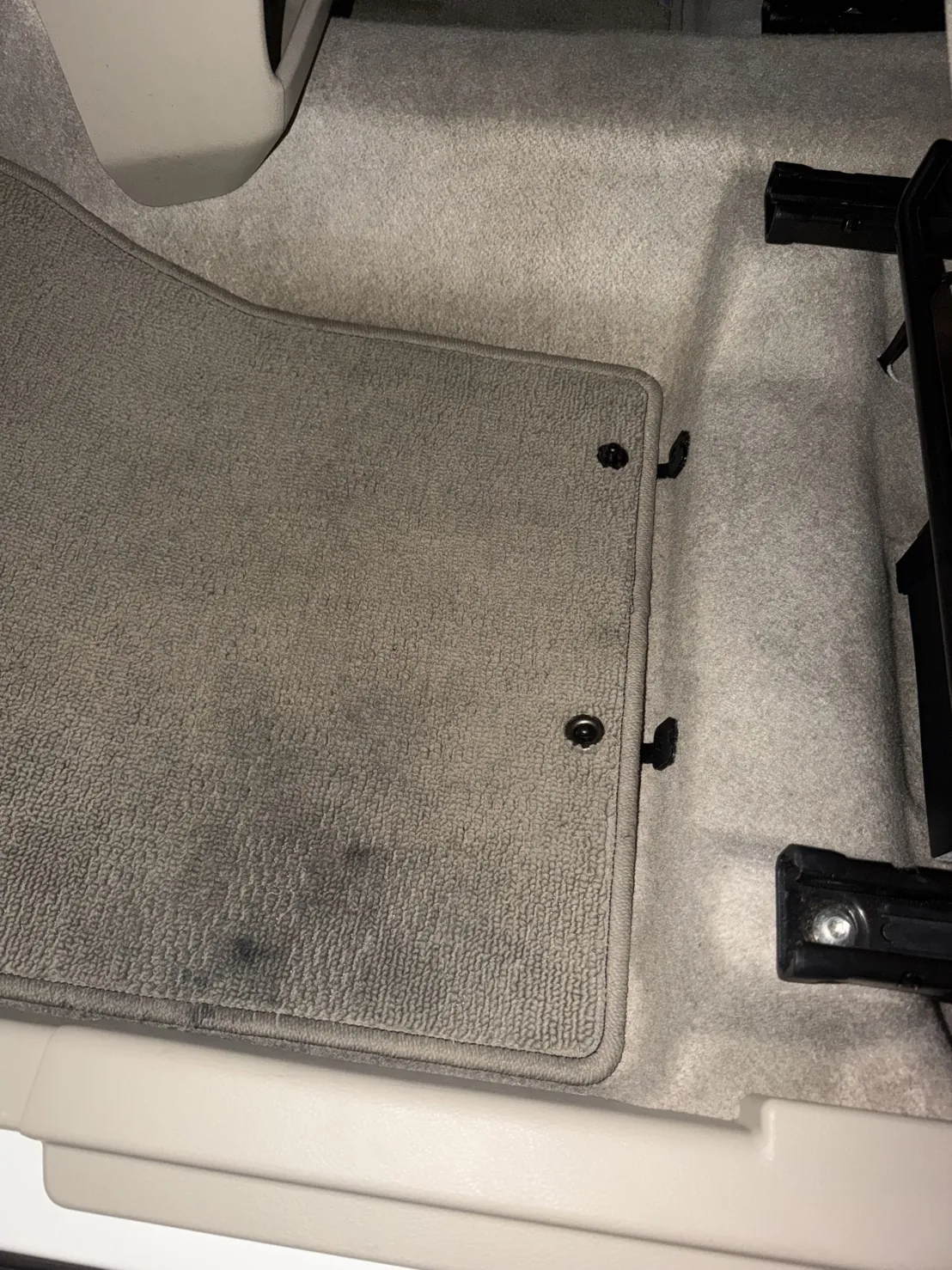 作業のあとの助手席の足元。1枚目と同じグレーのフロアマットで、同じ位置に留め具が2つある。ドア側の縁の近くに出ていた黒い跡が見当たらない