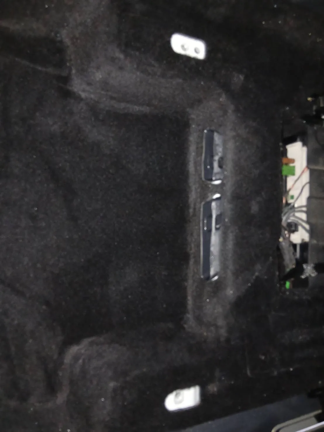 運転席まわりの床。黒いカーペットに白い取り付け部と黒いカバーが見え、右側に配線が通っている