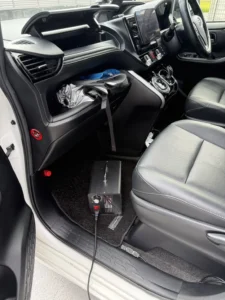 助手席の足元に置かれたオゾン発生器と、車外へ伸びる電源コード