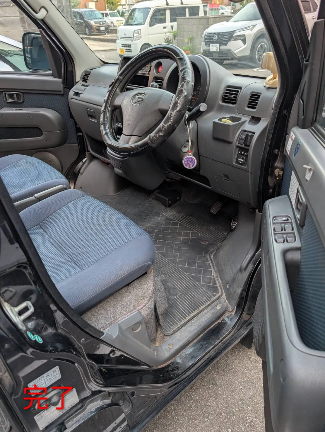 完了した運転席まわり。助手席側のドアから、ハンドルとダッシュボードが写り、足元に黒いゴム製のフロアマットが敷かれている