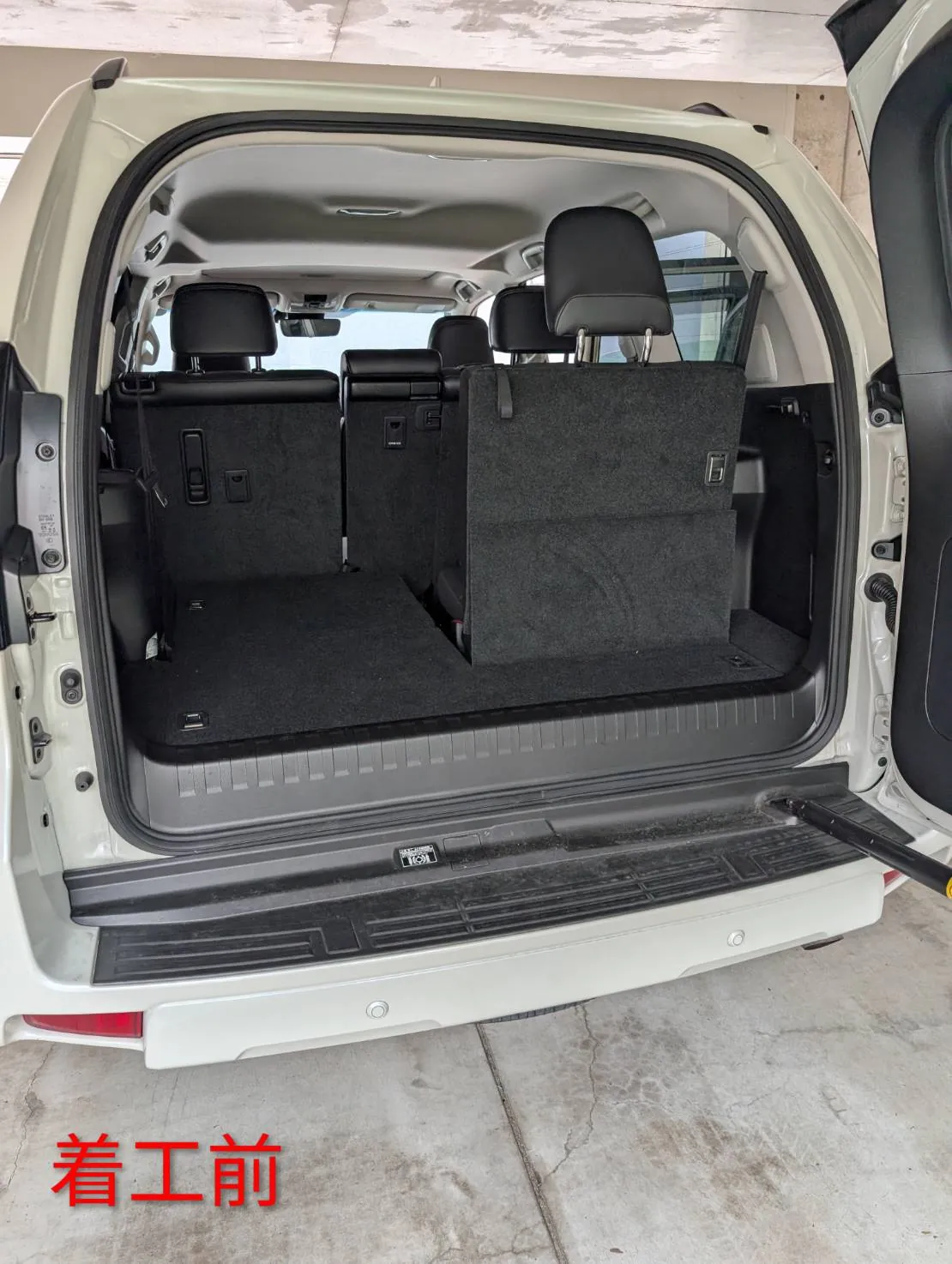 バックドアを開けて撮ったトヨタ ランドクルーザーの荷室。3列目は左側が床に格納され、右側は立ったまま。床は濃いグレーのカーペット