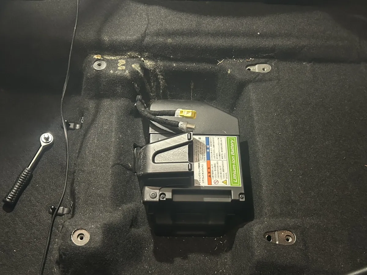 座席を外したあとの床を上から見たところ。中央の箱型の部品のへりに沿って黄土色のものが帯のように付いている